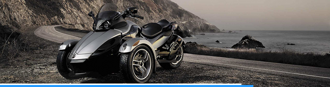 Silver 2018 Can-Am® ATV parked in front of a deserted highway